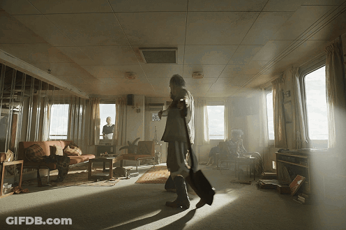 Man Walking Through Living Room With Woman On Couch GIF