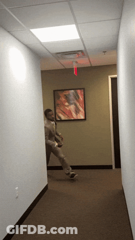 Man Walking Under Red Exit Sign GIF