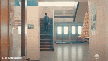 Man Walking Up Stairs In School Hallway GIF