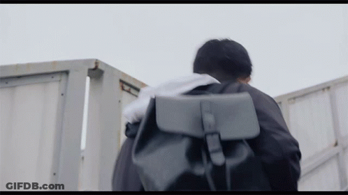 Man Walking With Backpack And Towel On Head GIF
