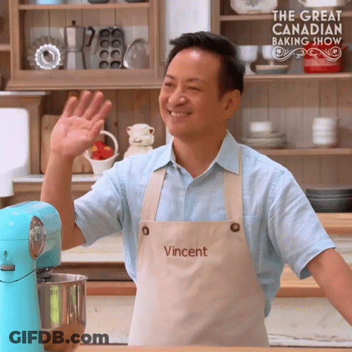 Man Wearing Apron Saying Vincent Waves Hand GIF