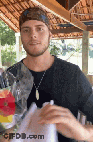 Man Wearing Bandana And Necklace Holding Bag Of Food GIF