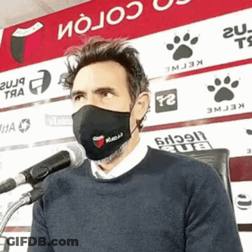 Man Wearing Face Mask Talking Into Microphone GIF