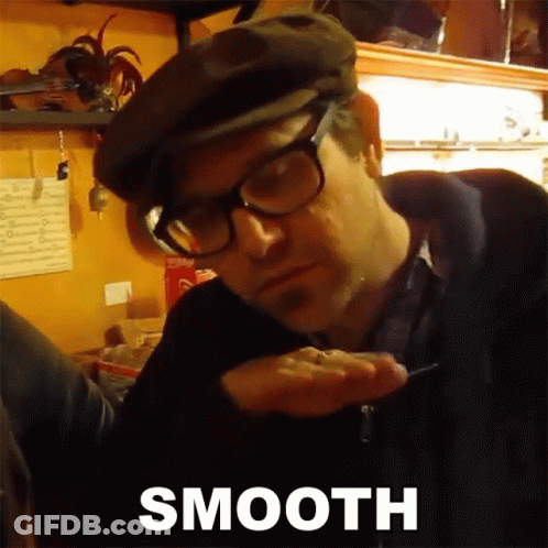 Man Wearing Glasses And Flat Cap Holding Something GIF