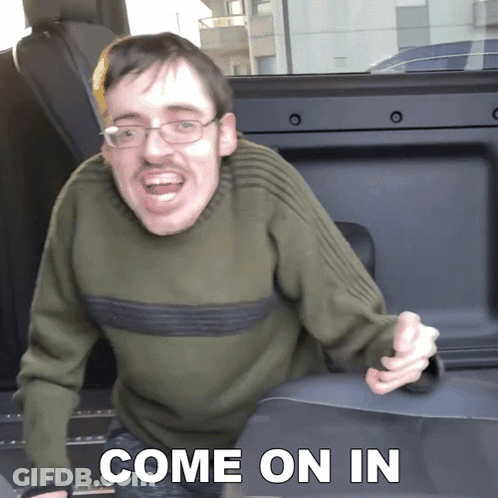 Man Wearing Glasses And Green Sweater Says Come On In Sitting In Back Seat Of Car GIF