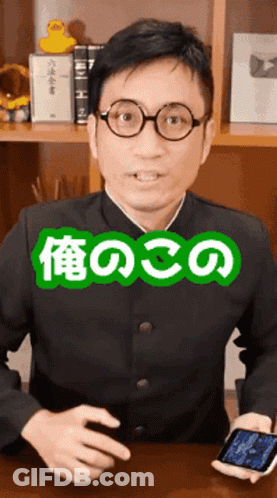 Man Wearing Glasses Holding Cell Phone In Front Of Bookshelf GIF
