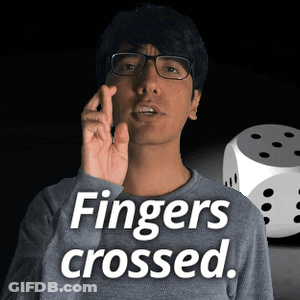 Man Wearing Glasses Saying Fingers Crossed Next To Dice GIF
