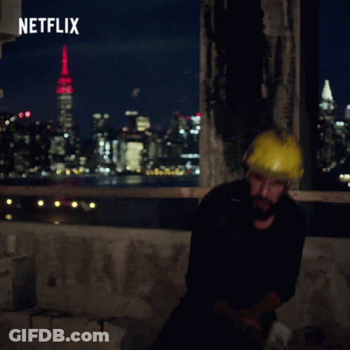 Man Wearing Hard Hat In Front Of Netflix Ad GIF