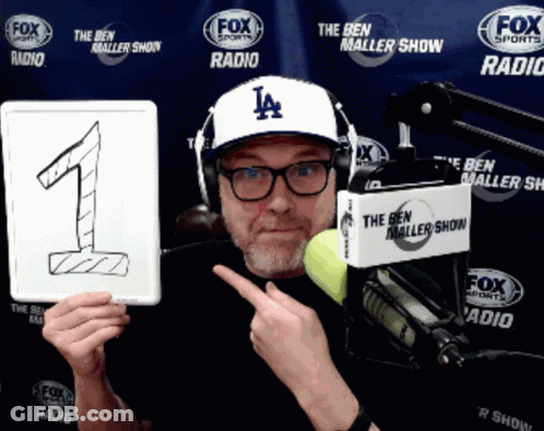 Man Wearing Hat Holding Number One Sign GIF