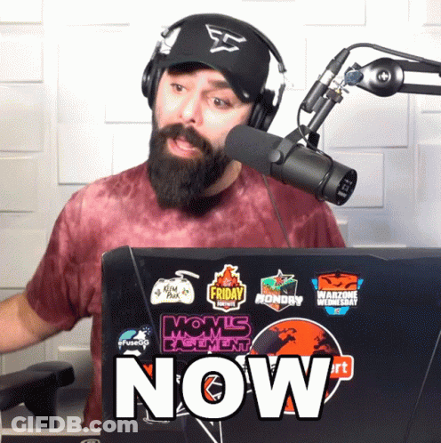 Man Wearing Headphones And Hat Stands In Front Of Laptop Saying Now GIF