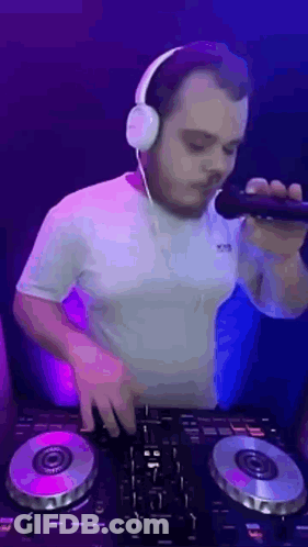 Man Wearing Headphones Holding Microphone At DJ Controller GIF