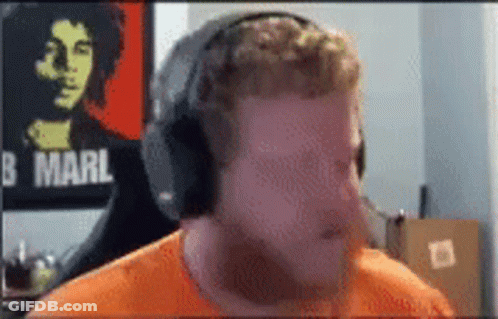 Man Wearing Headphones In Front Of Bob Marley Poster GIF