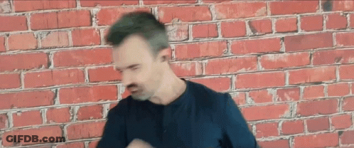 Man Wearing Headphones In Front Of Brick Wall GIF
