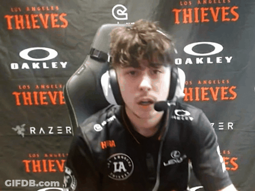 Man Wearing Headphones In Front Of Los Angeles Thieves Banner GIF