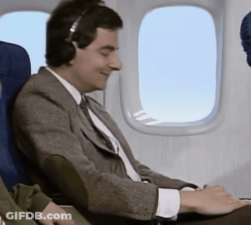 Man Wearing Headphones Looking Out Plane Window GIF