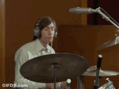 Man Wearing Headphones Playing Drum Set In Recording Studio GIF