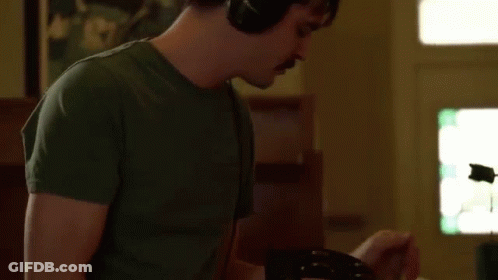 Man Wearing Headphones Playing Guitar In Living Room GIF