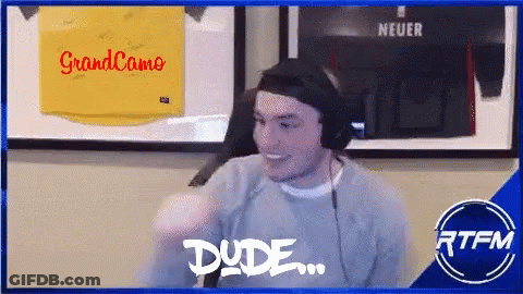Man Wearing Headphones Smiling In Front Of Grandcamo Sign GIF