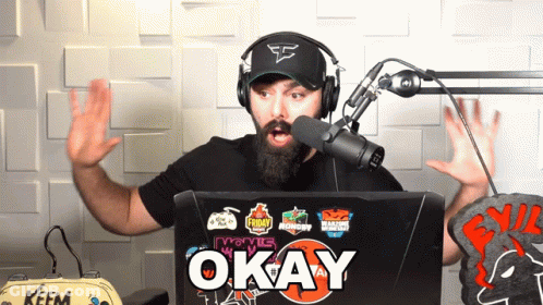 Man Wearing Headphones Stands In Front Of Laptop Says Okay GIF