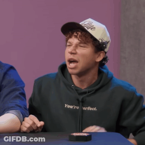 Man Wearing I'm Sitting Hat At Table GIF