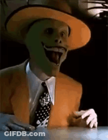 Man Wearing Mask And Hat Sitting With Tongue Out GIF