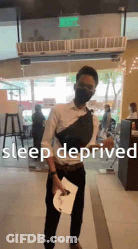 Man Wearing Mask Holds Paper In Front Of Sleep Deprived Sign GIF
