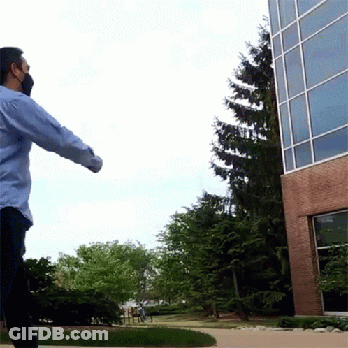 Man Wearing Mask In Front Of Building GIF