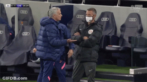 Man Wearing Mask Shakes Hands With Another Man In Front Of Audi Seats GIF