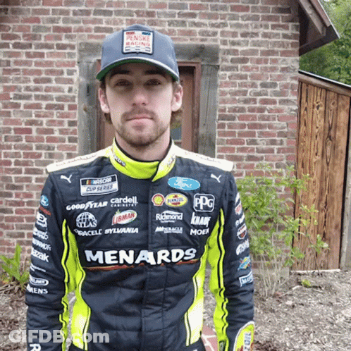 Man Wearing Menards Racing Suit At Brick Building GIF