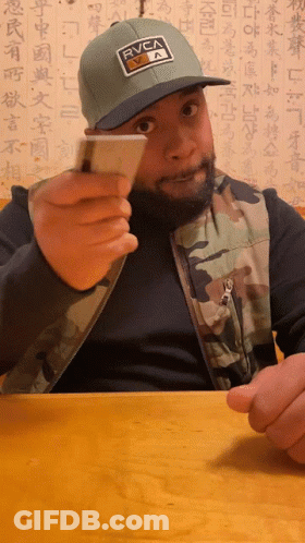 Man Wearing RVCA Hat Holding Card GIF