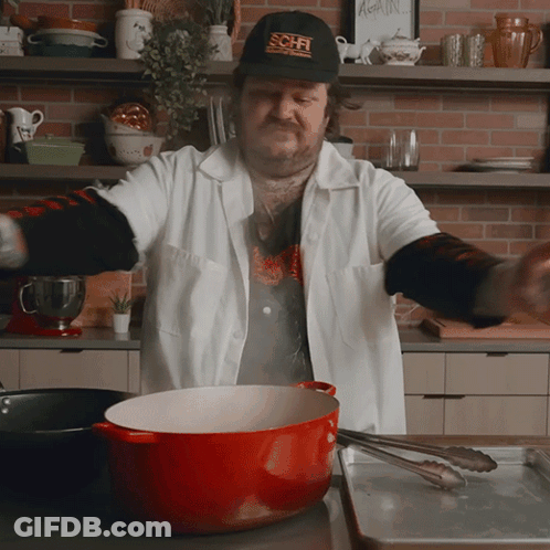 Man Wearing SciFi Hat Cooking In Kitchen GIF