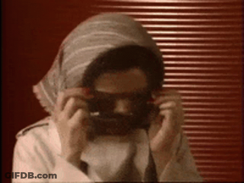 Man Wearing Sunglasses And Scarf Taking Selfie GIF