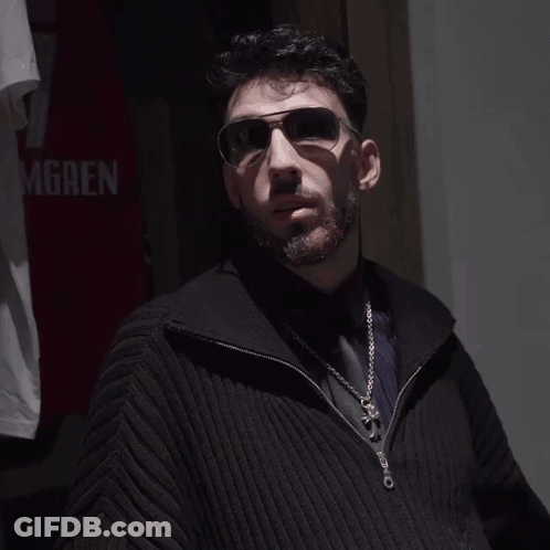 Man Wearing Sunglasses In Front Of Gren Shirt GIF