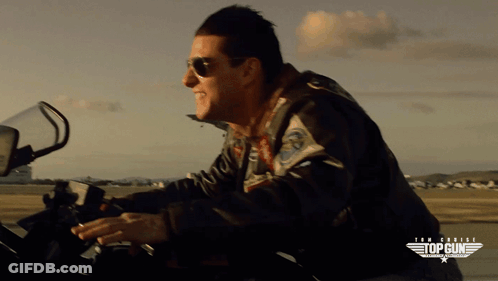 Man Wearing Sunglasses Riding Motorcycle With Top Gun Logo GIF
