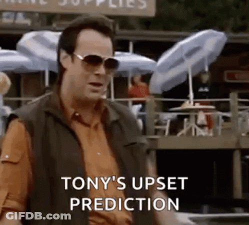 Man Wearing Sunglasses Standing In Front Of Restaurant With Umbrellas GIF