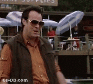 Man Wearing Sunglasses Standing In Front Of Supplies Sign GIF