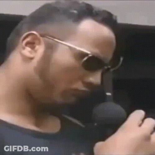 Man Wearing Sunglasses Talking Into Microphone GIF