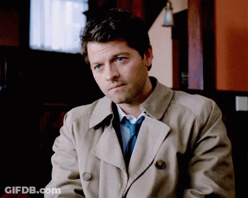 Man Wearing Trench Coat And Tie Sitting In Room GIF