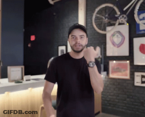 Man Wearing Watch In Front Of Bicycle Wheel GIF