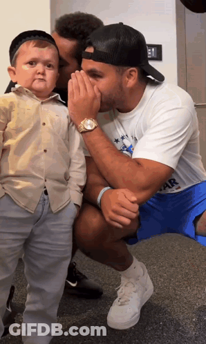 Man Whispering Into Another Man's Ear Wearing Star Shirt GIF