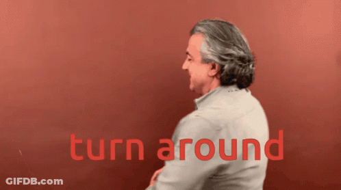 Man White Shirt Red Wall Saying Turn Around GIF