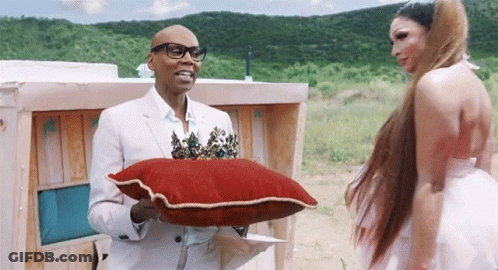 Man White Suit Holding Red Pillow Gold Trim GIF