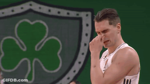 Man Wiping Nose In Front Of Green Shamrock GIF