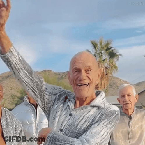 Man With Arm In Air Surrounded By Three People GIF