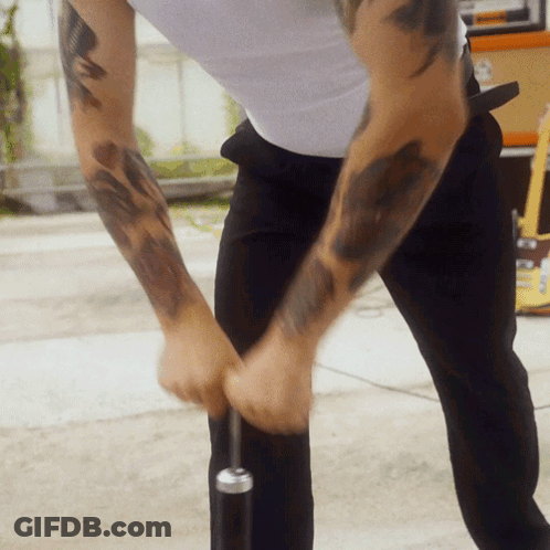 Man With Arm Tattoo Holding Microphone GIF