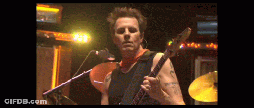 Man With Arm Tattoo Playing Guitar At Microphone GIF