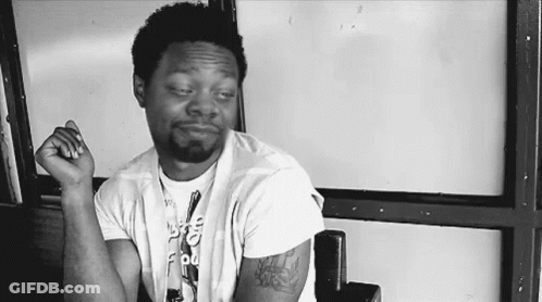 Man With Arm Tattoo Sitting Hands Folded GIF