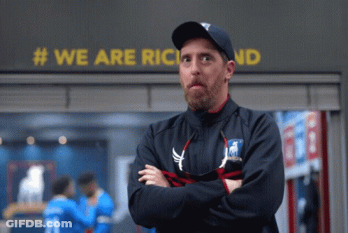 Man With Arms Crossed In Front Of We Are Richland Sign GIF