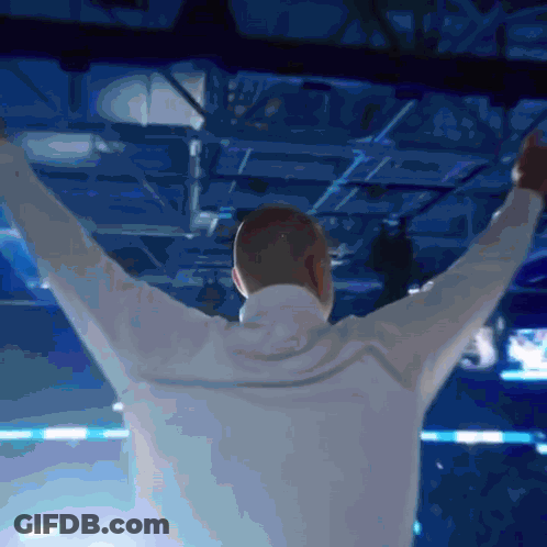 Man With Arms Outstretched In Blue Room GIF