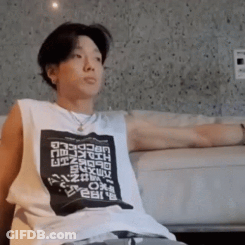 Man With Arms Outstretched On Couch In White Tank Top GIF